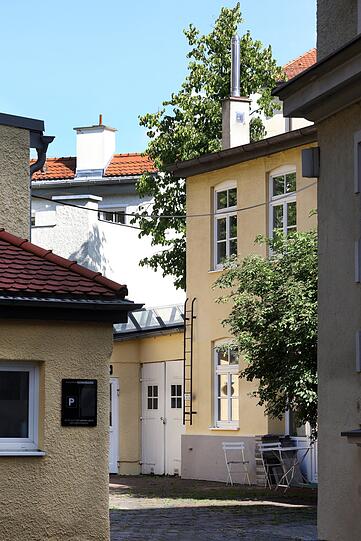Idylle: ein alter Hof mit Sitzgelegenheit und ein bisserl Grün.