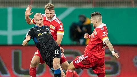 Sven Michel (l-r) vom SC Paderborn kämpft gegen Berlins Marvin Friedrich und Robert Andrich um den Ball.