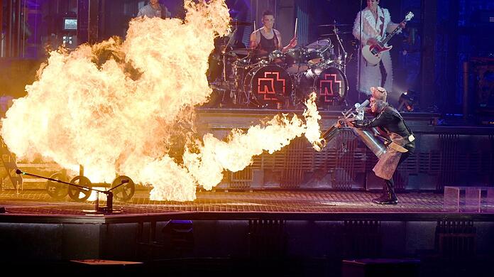 Rammstein sind auch legendär wegen ihrer Pyroshows. Hier feuert Frontsänger Till Lindemann (r.) mit einem Flammenwerfer auf der Bühne herum.