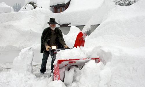 Nur noch mit einer Schneefräse kann dieser Mann in Kötschach- Mauthen in Kärnten den Weg zu seinem Haus freiräumen.