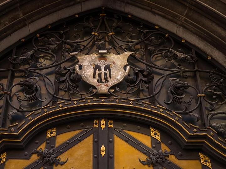 Das Wappen mit dem "Münchner Kindl" hängt über der Tür des Rathauses in der bayerischen Landeshauptstadt. Foto: Peter Kneffel/Archiv