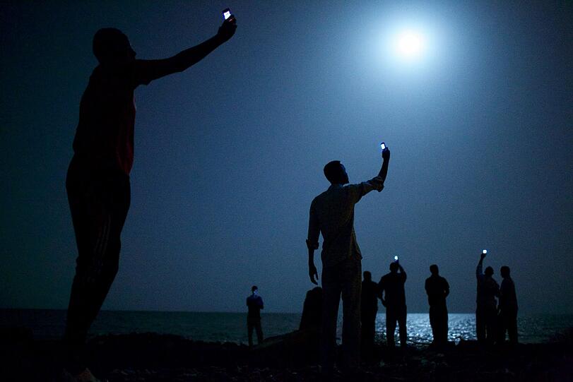 Der Gewinner 2014: Das Pressefoto des Jahres hat der US-amerikanische Fotograf John Stanmeyer gemacht. Es zeigt afrikanische Migranten am Strand von Dschibuti mit ihren Mobiltelefonen.