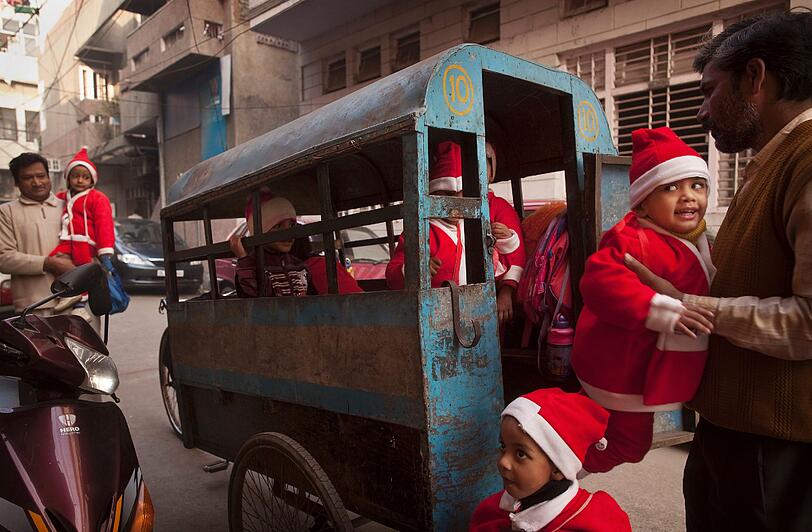 Schelmisch schaut dieser kleine Weihnachtsbub. Was hat er wohl in dem Wagen angestellt?