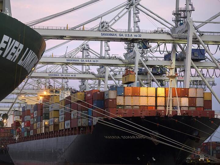 Container werden im Hafen von Savannah auf ein Schiff verladen. Nach dem Zoll-Rundumschlag von US-Präsident Trump brennt es in der Welthandelsorganisation (WTO) in Genf an allen Ecken und Enden.