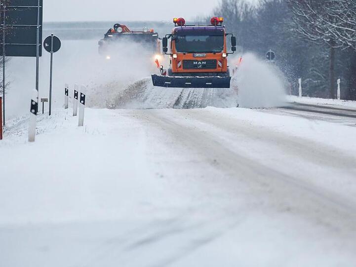Zwei Schneepflüge des Winterdienstes räumen eine schneebedeckte Bundesstraße in Baden-Württemberg. Auch für die Nacht zu Montag wird vor gefährlicher Glätte gewarnt.