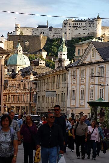 Touristen in der Altstadt von Salzburg unter der Festung Hohensalzburg.