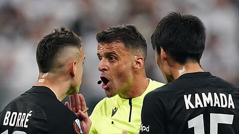 Rafael Borre (l) und Daichi Kamada diskutieren mit Schiedsrichter Jesus Gil Manzano.