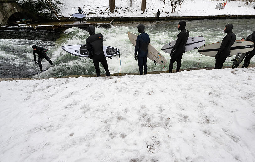 Bei Wind und Wetter auf dem Wasser: Die Surfer an der Eisbachwelle.