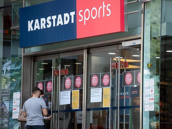 Passanten vor einem Eingang einer Filiale von Karstadt Sports.