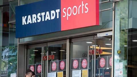 Passanten vor einem Eingang einer Filiale von Karstadt Sports.