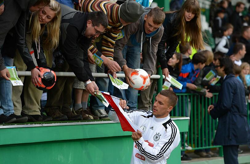 "Dankeschön, Polen" und "Gefällt mir" auf Polnisch - mit 11.000 Fans gerät das erste DFB-Training in Polen zum herzlichen Willkommensfest - und zur Geburtstagsparty für Lukas Podolski.
