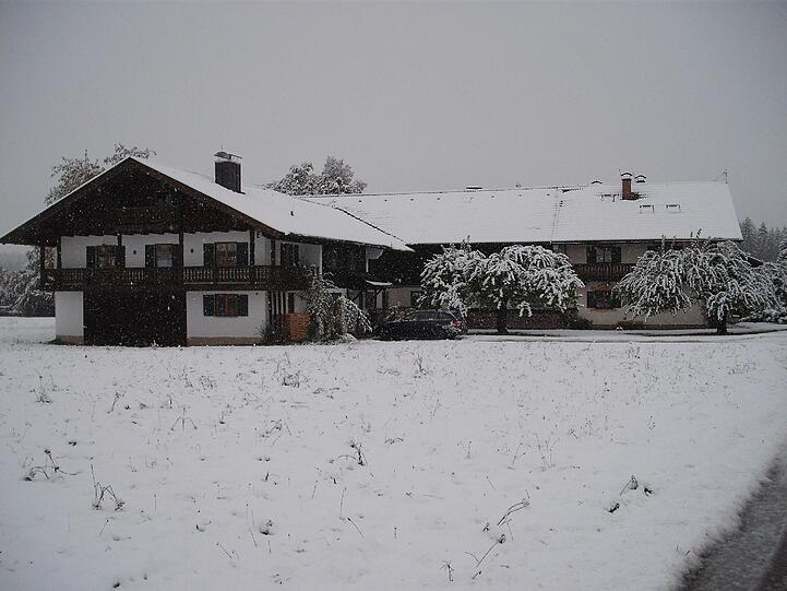 Am Donnerstagabend waren die Wiesn in Holzkirchen noch grün - heute Morgen liegt eine Schneedecke über den Wiesn und Dächern.