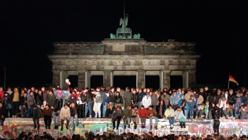 Jubelnde Menschen sitzen nach der Maueröffnung auf den Grenzanlagen am Brandenburger Tor. Jubelnde Menschen sitzen nach der Maueröffnung auf den Grenzanlagen am Brandenburger Tor.