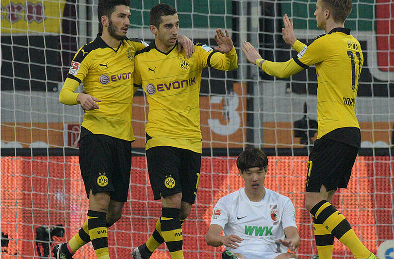 Die Dortmunder Nuri Sahin (l) und Marco Reus gratulieren Henrikh Mkhitaryan nach dessen Tor zum zwischenzeitlichen 1:1-Ausgleich gegen den FC Augsburg.