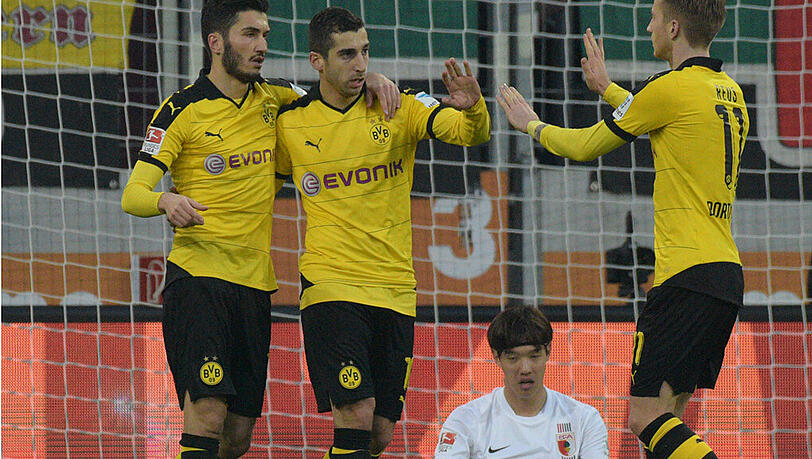 Die Dortmunder Nuri Sahin (l) und Marco Reus gratulieren Henrikh Mkhitaryan nach dessen Tor zum zwischenzeitlichen 1:1-Ausgleich gegen den FC Augsburg.