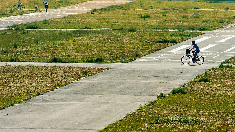 Ein Fahrradfahrer radelt völlig ungehindert über die Theresienwiese – der Wiesnaufbau, der in diesen Tagen beginnen würde, fällt ja heuer erneut flach.