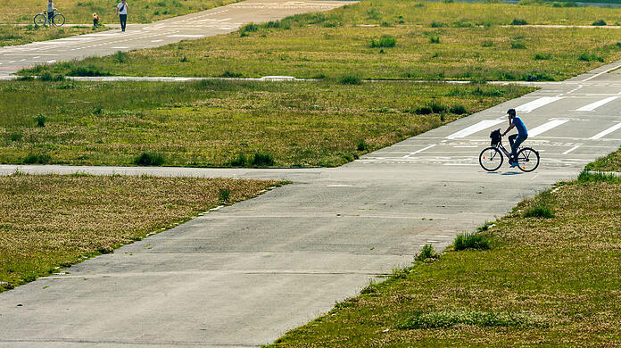 Ein Fahrradfahrer radelt völlig ungehindert über die Theresienwiese – der Wiesnaufbau, der in diesen Tagen beginnen würde, fällt ja heuer erneut flach.