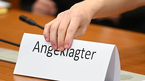 Ein Schild mit der Aufschrift "Angeklagter" wird auf die Gerichtsbank gestellt (Symbolbild).
