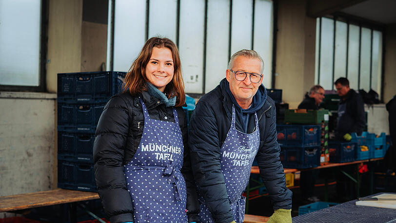 Selina Weininger und Hubert Fischer engagieren sich ehrenamtlich bei der M&uuml;nchner Tafel. Kurz vor Weihnachten sorgen sie mit den anderen Helfern daf&uuml;r, dass die Ausgabe f&uuml;r Hunderte Menschen reibungslos l&auml;uft.
