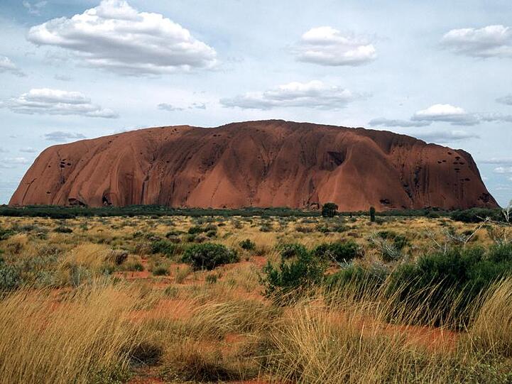 Eines der bekanntesten Wahrzeichen Australiens, der riesige Sandstein Uluru oder Ayers Rock ist in der zentralaustralischen Wüste zu sehen.