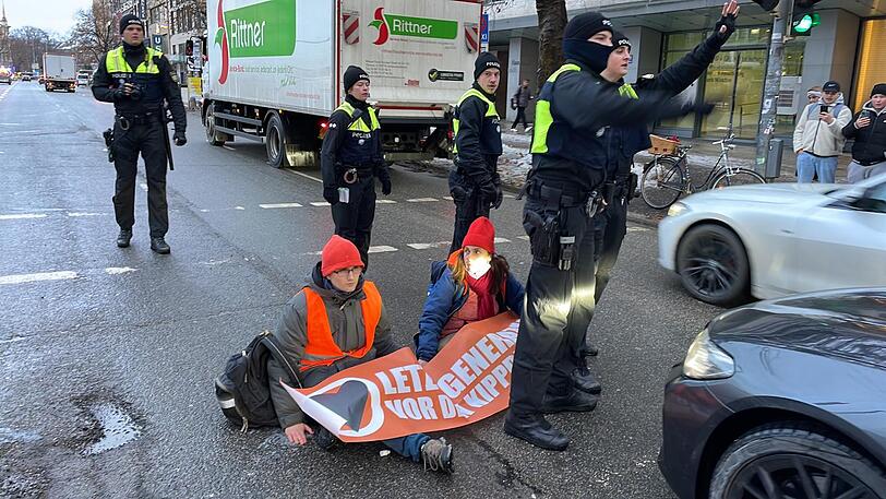 Zwei Aktivisten haben sich an der Ecke Sonnenstraße/Schwanthalerstraße festgeklebt.