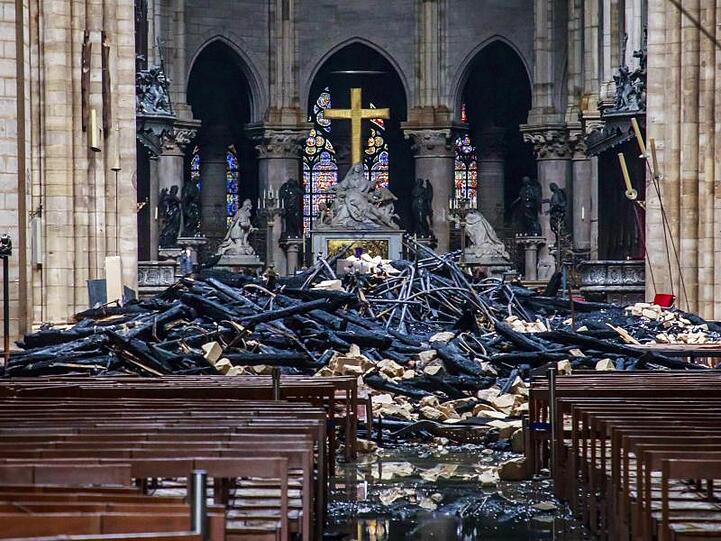 Trümmerteile und verkohlte Holzbalken liegen im Inneren der Kathedrale Notre-Dame.