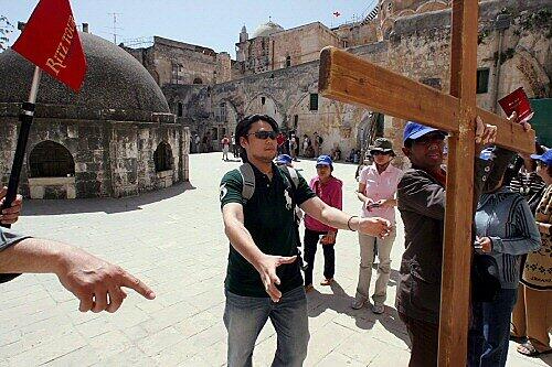 Ein Tour-Guide demonstriert den Umgang mit dem Kreuz