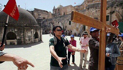 Ein Tour-Guide demonstriert den Umgang mit dem Kreuz Ein Tour-Guide demonstriert den Umgang mit dem Kreuz