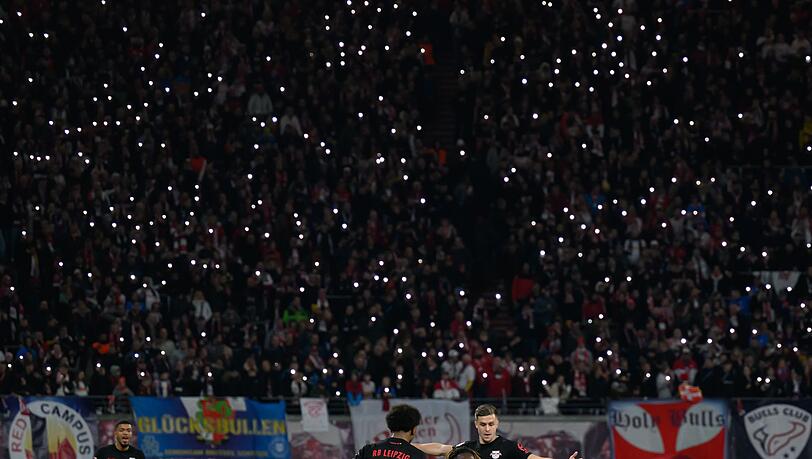 Die Zuschauer im Stadion lassen in Gedenken an einen gestorbenen Fan die Lichter ihrer Handys leuchten.