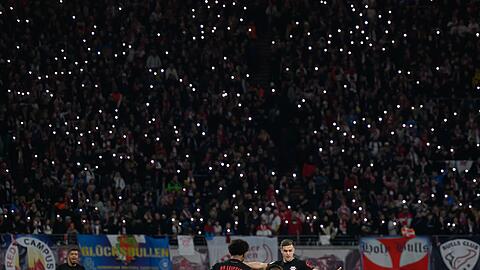 Die Zuschauer im Stadion lassen in Gedenken an einen gestorbenen Fan die Lichter ihrer Handys leuchten.