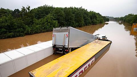 Drei Lastwagen stehen auf der überfluteten Bundesstraße 265 im tiefen Wasser und sind kaum mehr zu erkennen.