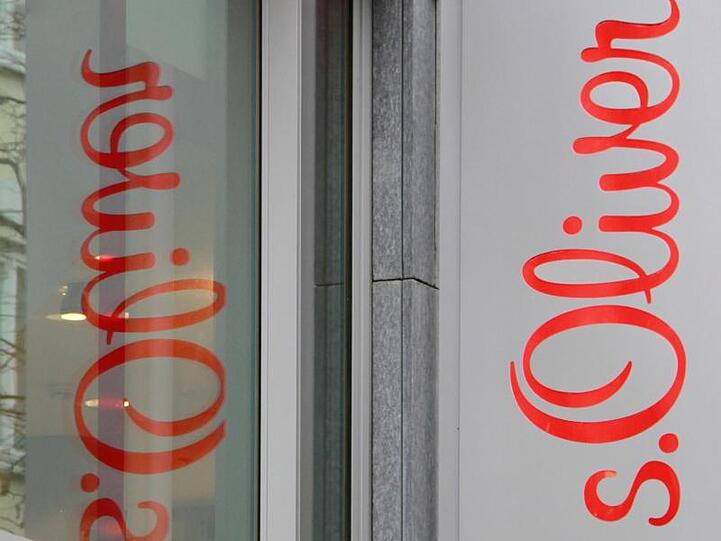 Eine Reklame der Firma s. Oliver spiegelt sich in einem Fenster in München. Foto: Rene Ruprecht