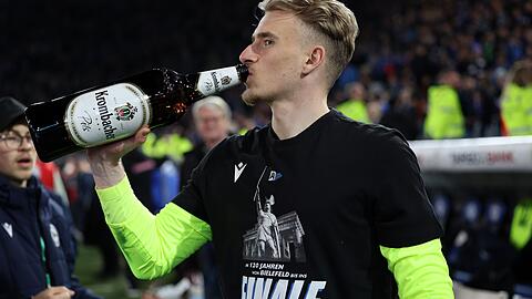 Torwart Jonas Kersken feiert mit Bier und Finalshirt.