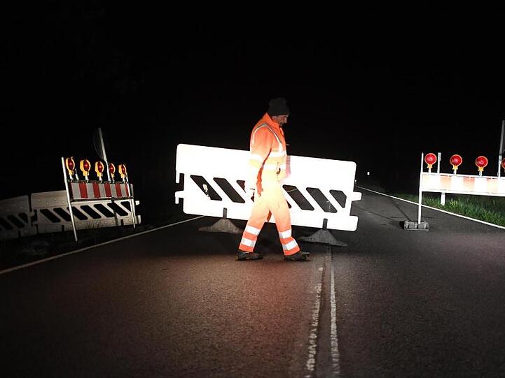 Ein Mitarbeiter baut Absperrgitter an der Grenze ab. Foto: Angelika Warmuth/dpa