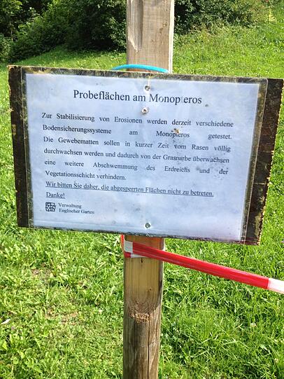 Ein Schild weist auf die Probleme mit rutschendem Erdreich am Monopteros hin.