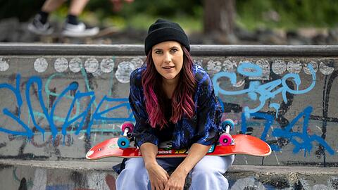 Elisabeth Furtwängler sitzt mit ihrem Skateboard im Berliner Skatepark Gleisdreieck.