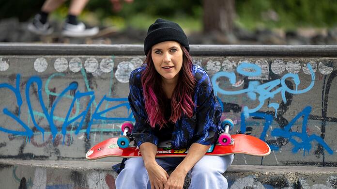 Elisabeth Furtwängler sitzt mit ihrem Skateboard im Berliner Skatepark Gleisdreieck.