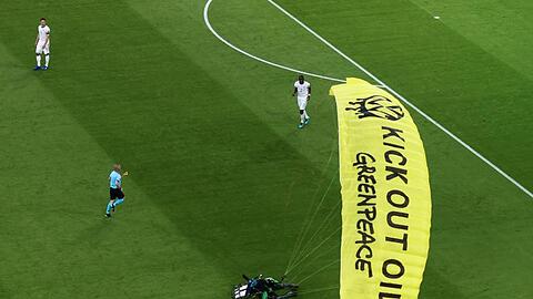 Ein Greenpeace-Aktivist landet auf dem Spielfeld.