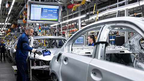Mitarbeiter von BMW arbeiten im Stammwerk in der Produktion an der Karosserie von Autos. Sie k&ouml;nnen kein Homeoffice machen.