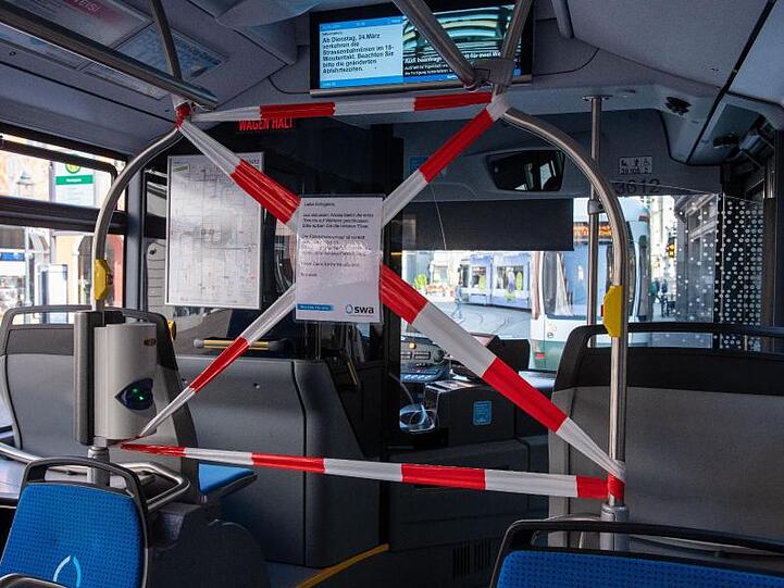 Der Vordereingang dieses Linienbusses in Augsburg ist zum Schutz vor einer Infektion mit dem Coronavirus abgesperrt.