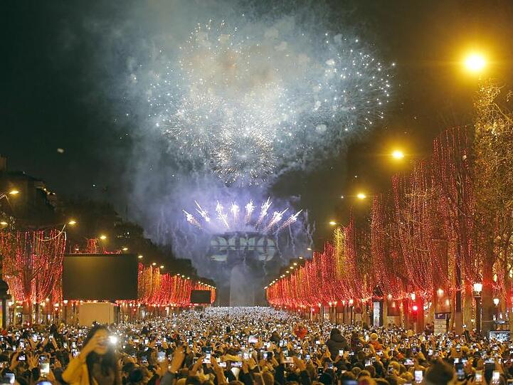 Mit Feuerwerk und einer spektakulären Lichtershow am Triumphbogen haben Tausende in Paris das neue Jahr begrüßt.