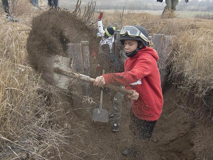 Kinder aus einem Waisenhaus helfen den Verteidigern der Stadt Mariupol, Schützengräben auszuheben.