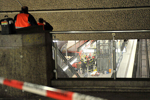 Ein Blick in den U-Bahnhof Rathenauplatz: Kurz nach dem Unglück bemühen sich Helfer der Feuerwehr, die Leiche der 54-jährigen Frau zu bergen, die noch unter der eingefahrenen U3 liegt. Die Frau war auf die Gleise gestürzt, die Bahn konnte nicht rechtzeitig halten.
