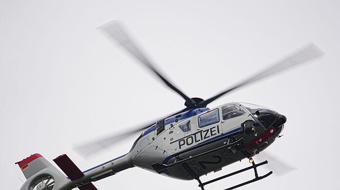 Ein Polizeihubschrauber fliegt bei einem Sucheinsatz über eine Stadt.