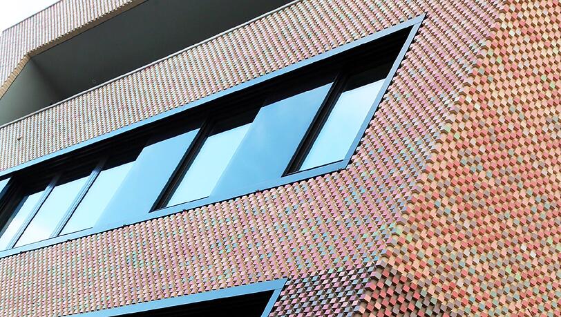 Farb-Fassade: Dieses Haus in der Königinstraße hat bunt schimmernde Schuppen. Farb-Fassade: Dieses Haus in der Königinstraße hat bunt schimmernde Schuppen.