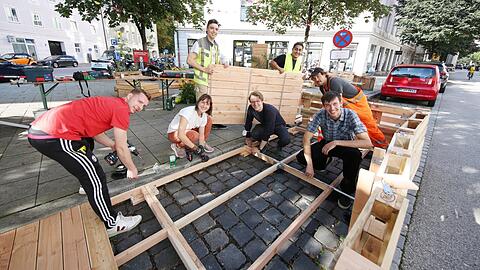 Die Studenten vom Kollektiv "Die Städtischen" hämmern und schrauben das neue Haidhauser Parklet hier eigenhändig zusammen.