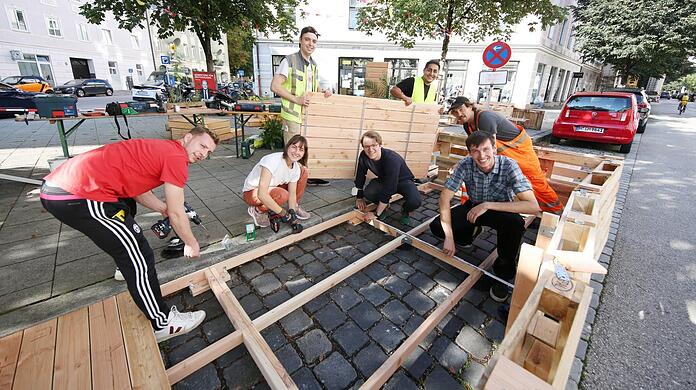 Die Studenten vom Kollektiv "Die Städtischen" hämmern und schrauben das neue Haidhauser Parklet hier eigenhändig zusammen.