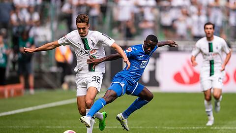 Hoffenheims Diadie Samassekou (r) versucht Gladbachs Florian Neuhaus vom Ball zu trennen.