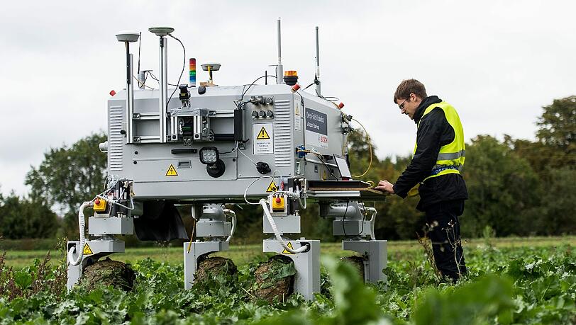 Ein Bosch Mitarbeiter steht auf einem Feld neben dem Agrarroboter Bonirob. Die Landwirtschaft steht vor einem tiefgreifenden Wandel. Foto: Daniel Maurer Ein Bosch Mitarbeiter steht auf einem Feld neben dem Agrarroboter Bonirob. Die Landwirtschaft steht vor einem tiefgreifenden Wandel. Foto: Daniel Maurer