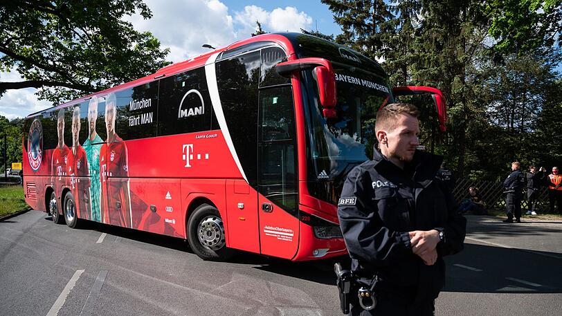 Der Mannschaftsbus des FC Bayern wird bei der Einfahrt zum Stadion von der Polizei bewacht.